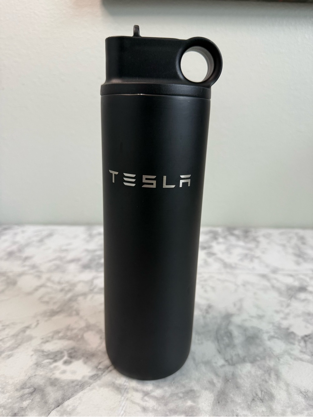 matte black Tesla stainless steel water bottle featuring a silver embossed Tesla